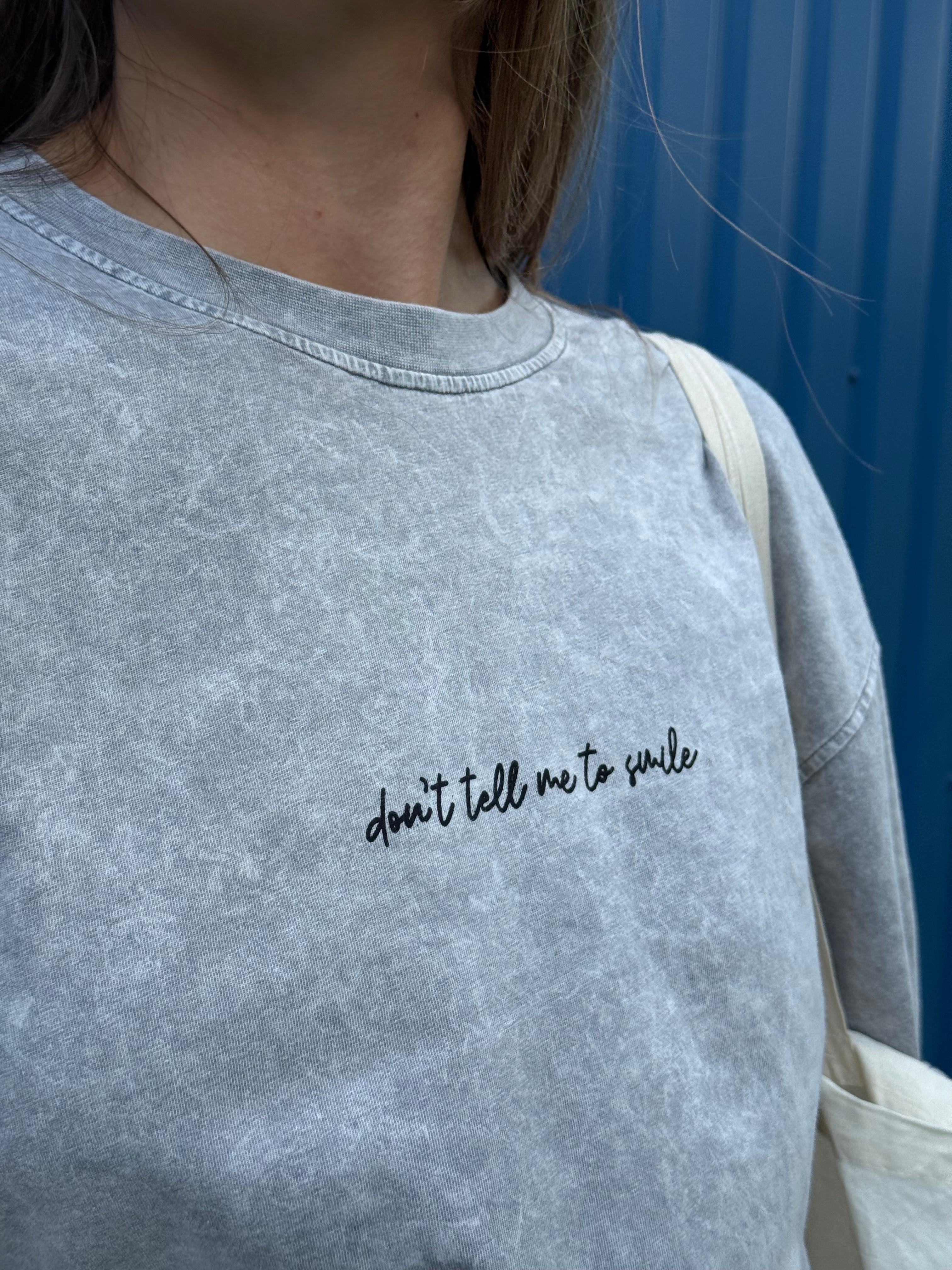 Pilki oversized „DON'T TELL ME TO SMILE“ marškinėliai - Jonyk