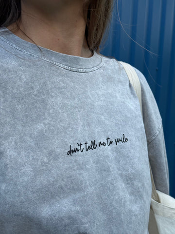 Pilki oversized „DON'T TELL ME TO SMILE“ marškinėliai - Jonyk